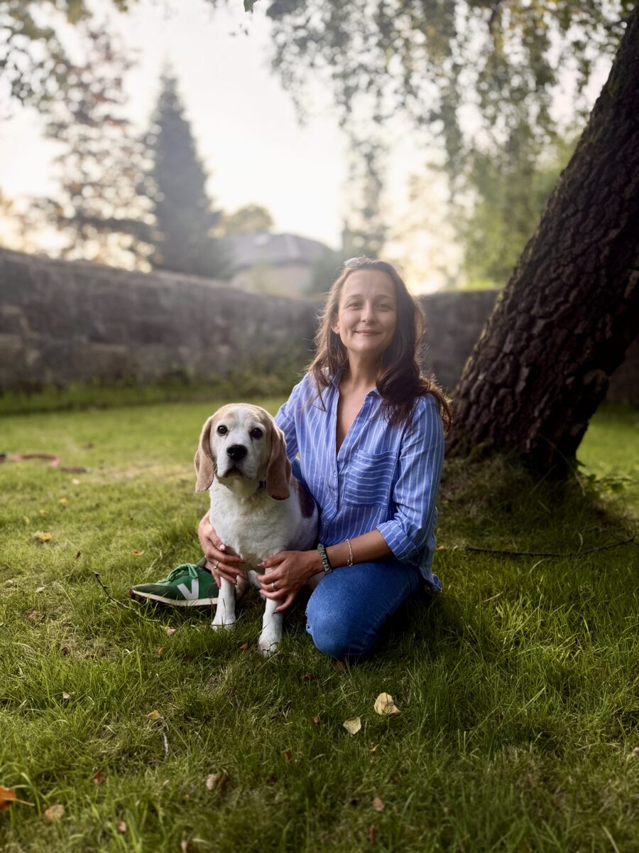 Katie Lunn, registered veterinary nurse, sitting outdoors with a beagle