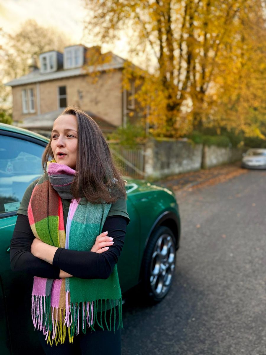 Katie Lunn, Nursing Director and registered veterinary nurse at Home Vet Nurse, in a colourful scarf on an autumn street